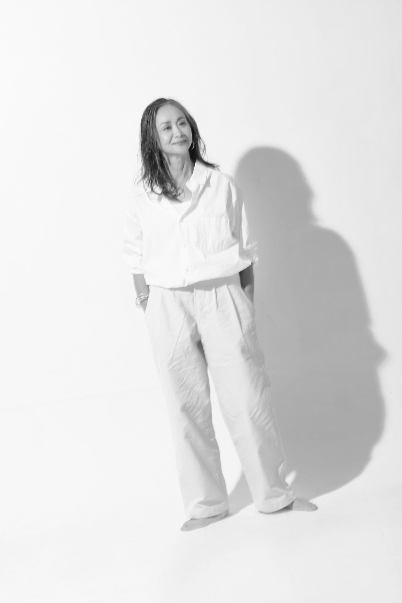 白い服をまとったシニア女性の全身モノクロポートレート