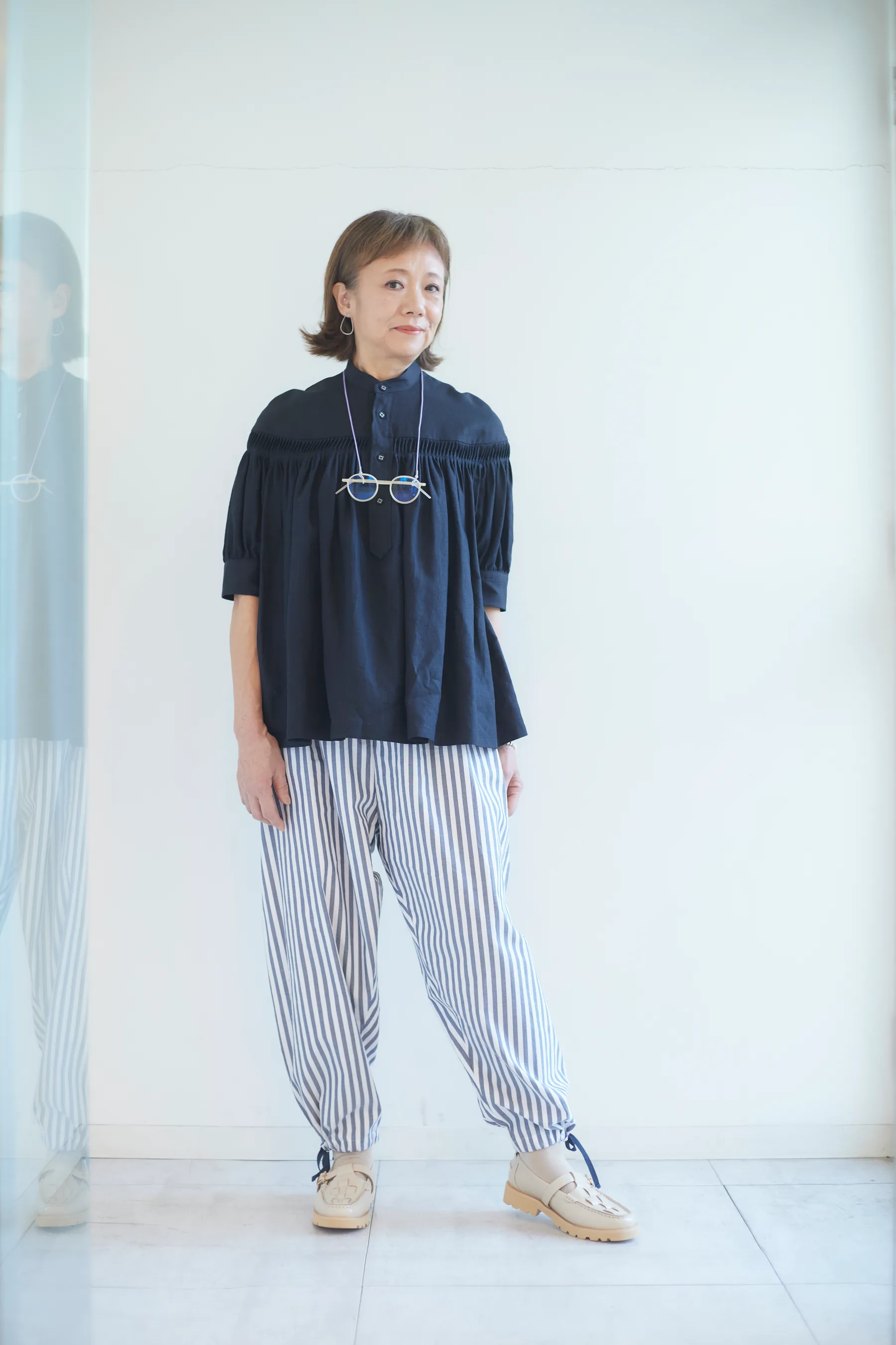 眼鏡を首に掛けたシニア女性