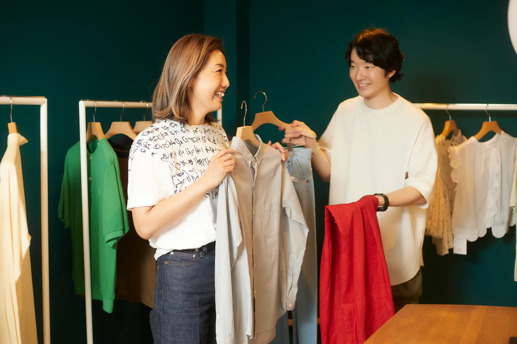 洋服を見ながら相談する展示販売会の参加者